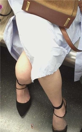 地铁拍摄低头玩手机的小清新美女