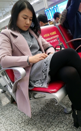 高铁站候车的黑色丝袜灰色连衣裙皮鞋少妇
