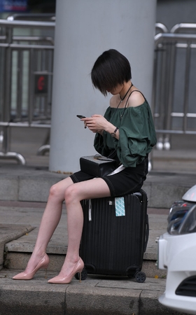 坐在箱子上等人的高跟美腿