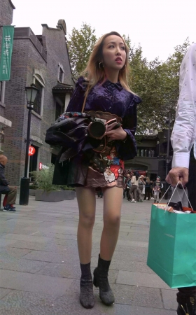 手持单反的时尚美裙美腿姑娘
