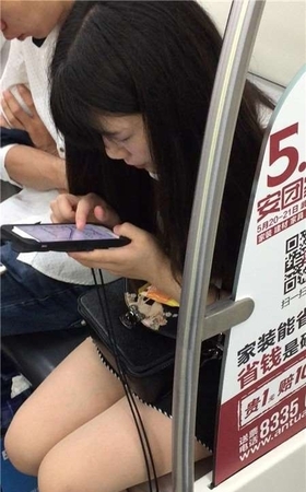 地铁上专心玩手机的美腿小清纯美女