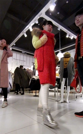 商场挑衣服的紧身白裤美女