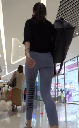 商场里戴着墨镜的紧身裤美女