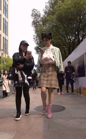 粉色短靴短裙卷发女子