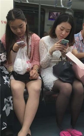 对面坐的两美女有点小诱惑，还让不让人好好坐地铁啦。