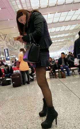 高铁站拍摄超短裙黑色丝袜高跟长发少妇