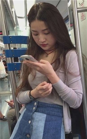 丰满长发牛仔裙美女，就这么一动不动的玩手机，任你摄。
