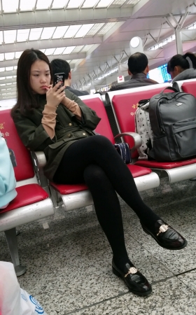 高铁站候车的黑色打底丝袜性感长腿美眉
