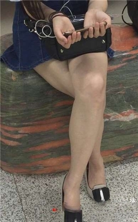 尖嘴高跟齐逼牛仔短裙妹子坐在玉石上看手机视频。