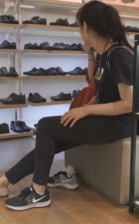 妈妈带着女儿来商场试穿鞋试完鞋后穿上白色袜子