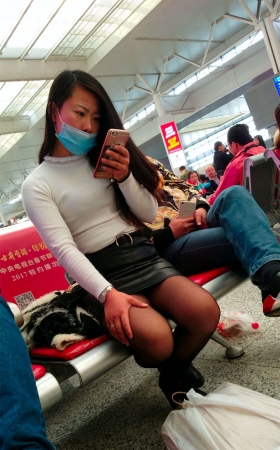 高铁站候车的黑色紧绷包臀皮裙黑丝长发少妇