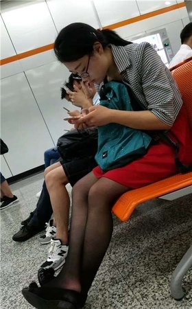 街拍黑丝眼镜妹，玩手机真入迷