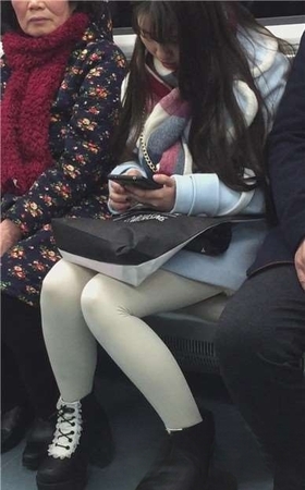 低头玩手机的白丝袜美腿可爱萌妹子。