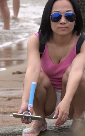 沙滩蹲着的牛仔热裤少妇