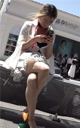 低头玩手机的丝袜高跟气质美女