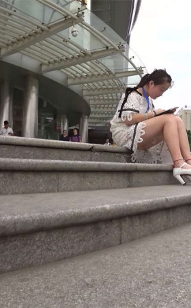 街拍专心玩手机的白色高跟白色蕾丝连衣短裙美眉