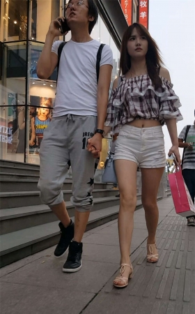 白色紧绷热裤长发美女和男友一起逛街