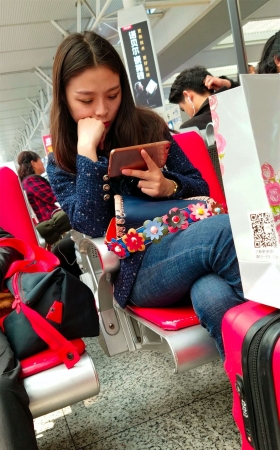 高铁站候车的蓝色紧身牛仔裤长发美少妇