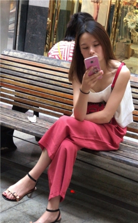 路边玩手机的小妹