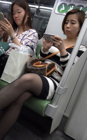地铁上玩手机的黑丝美女